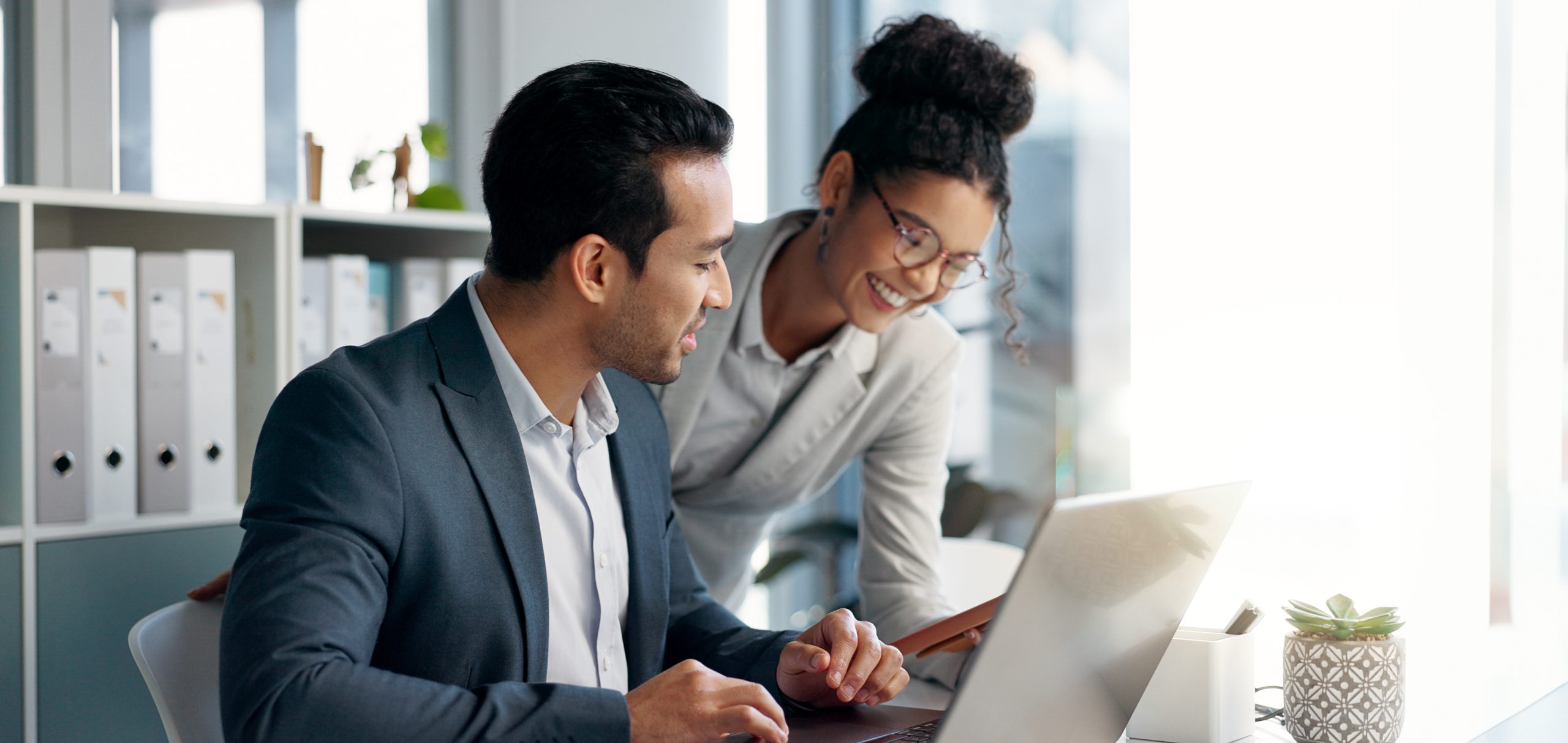 Two HR professionals in office working together on employee benefits to demonstrate Vortex SAP human resources experience.