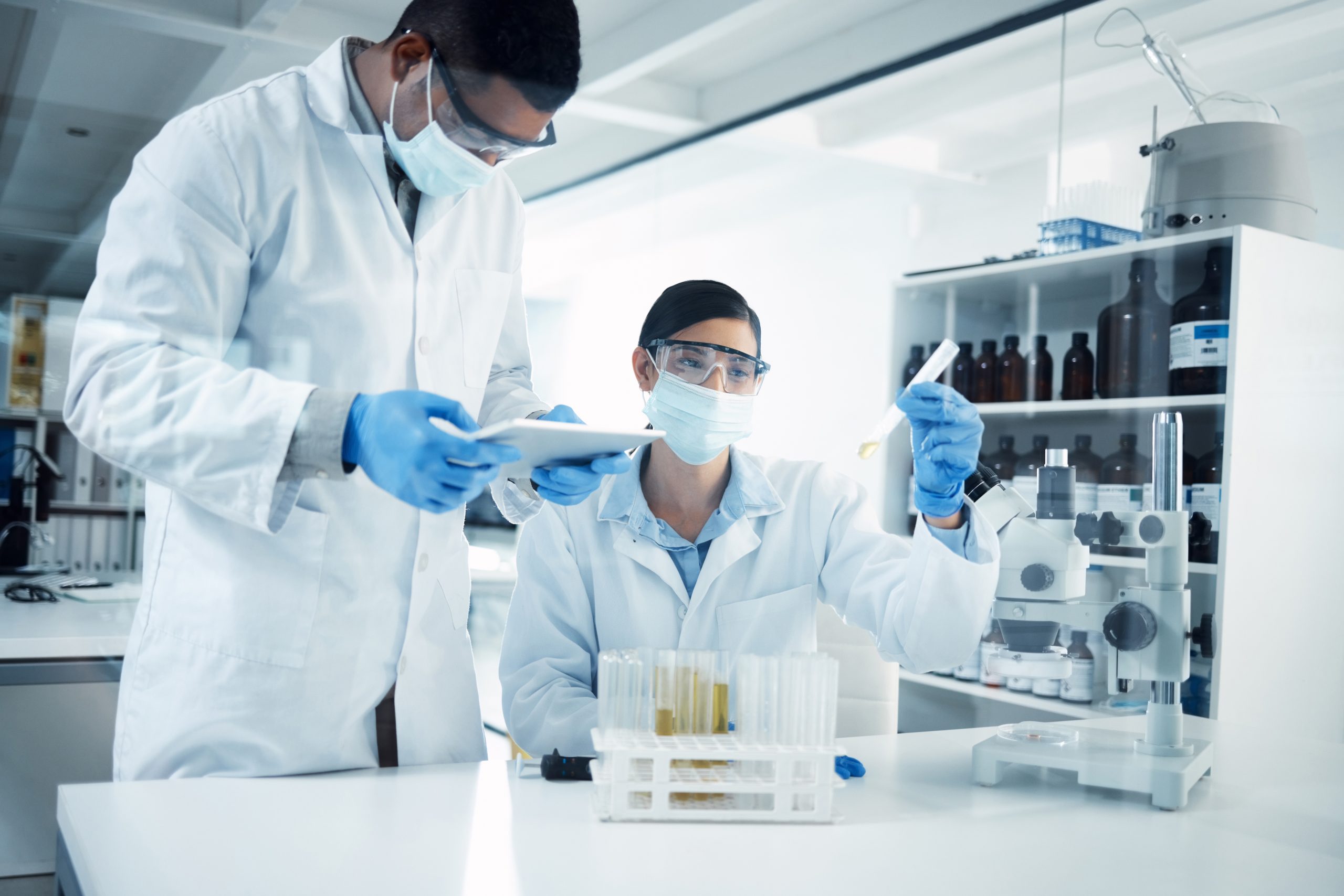 Two researchers wearing white lab coats in laboratory to show Vortex SAP life sciences experience.