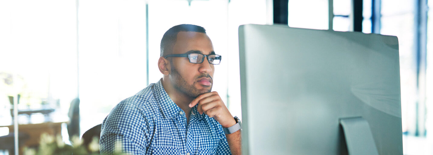 Office employee looks at screen representing SAP consultant blog post writing.